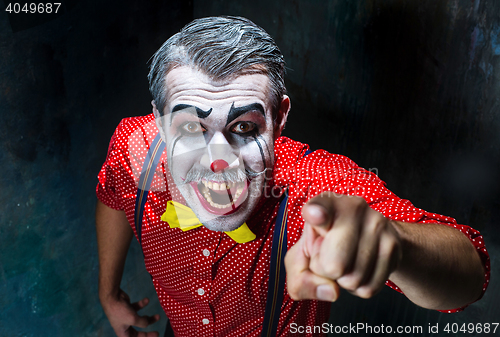 Image of Terrible clown and Halloween theme: Crazy red clown in a shirt with suspenders