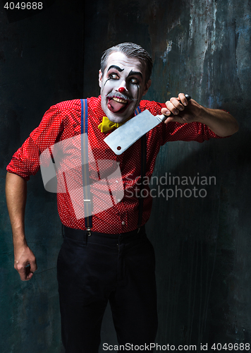 Image of The crazy clown holding a knife on dack. Halloween concept