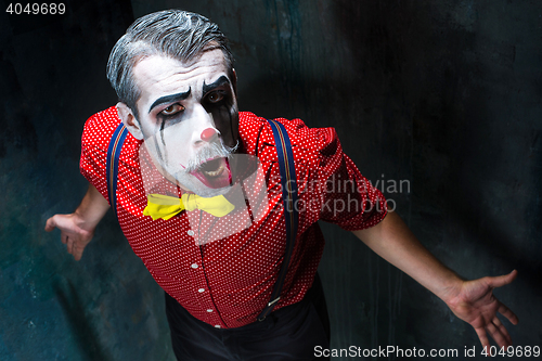 Image of Terrible clown and Halloween theme: Crazy red clown in a shirt with suspenders