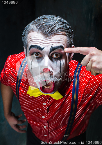 Image of Terrible clown and Halloween theme: Crazy red clown in a shirt with suspenders