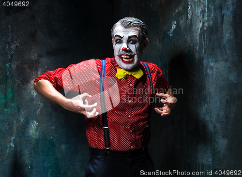 Image of Terrible clown and Halloween theme: Crazy red clown in a shirt with suspenders