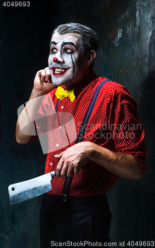 Image of The crazy clown holding a knife on dack. Halloween concept