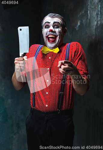 Image of The scary clown holding a knife on dack. Halloween concept