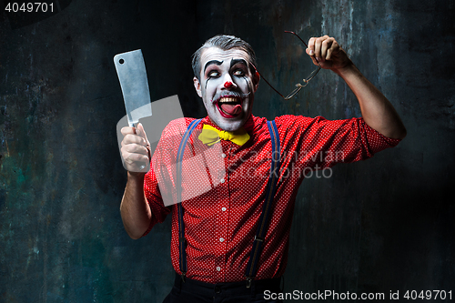 Image of The scary clown holding a knife on dack. Halloween concept