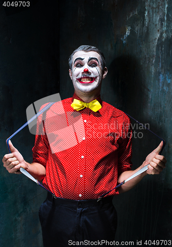 Image of Terrible clown and Halloween theme: Crazy red clown in a shirt with suspenders