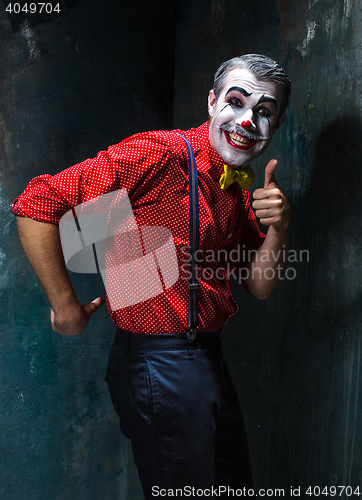 Image of Terrible clown and Halloween theme: Crazy red clown in a shirt with suspenders