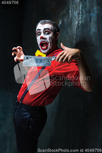 Image of The crazy clown holding a knife on dack. Halloween concept