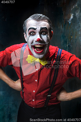 Image of Terrible clown and Halloween theme: Crazy red clown in a shirt with suspenders