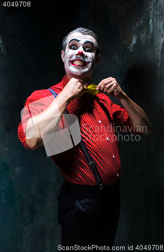 Image of Terrible clown and Halloween theme: Crazy red clown in a shirt with suspenders