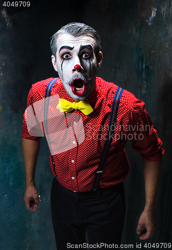 Image of Terrible clown and Halloween theme: Crazy red clown in a shirt with suspenders