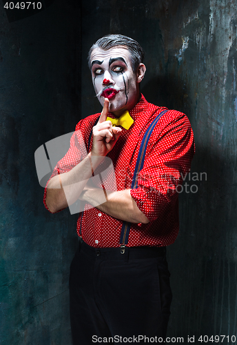 Image of Terrible clown and Halloween theme: Crazy red clown in a shirt with suspenders