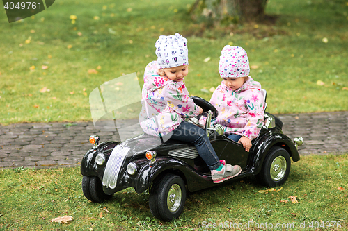 Image of The little baby girl playing at car