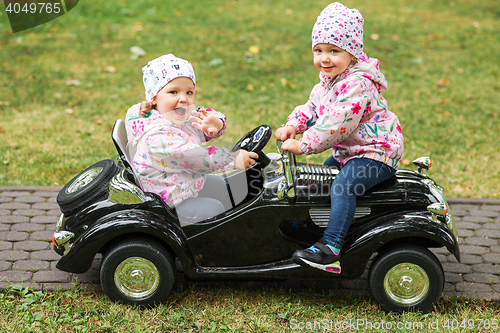 Image of The little baby girl playing at car