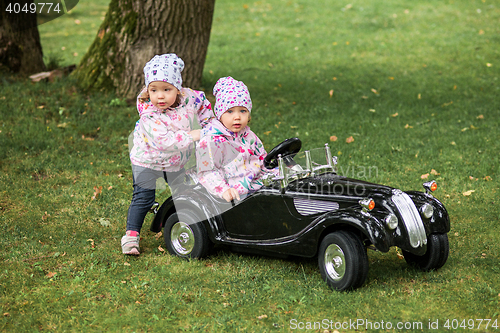 Image of The little baby girl playing at car