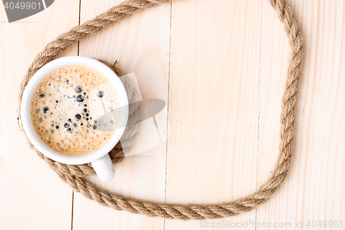 Image of Cup of coffee with foam on wooden table