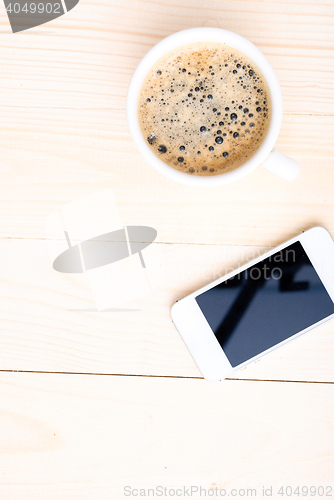 Image of Cup of coffee with foam on wooden table