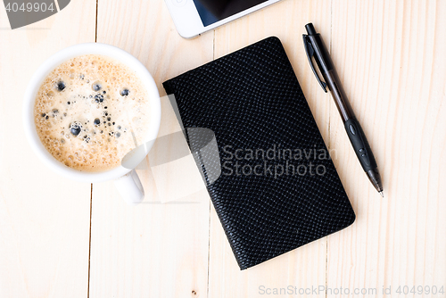 Image of Smartphone with notebook and cup of strong coffee