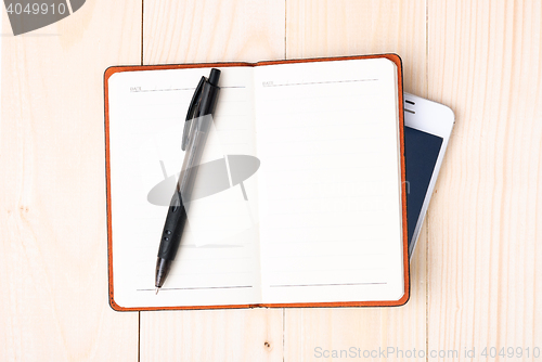 Image of Small notepad with pen and smartphone