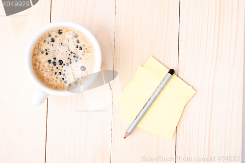 Image of Wood desk with office supplies and cup of coffee