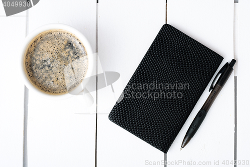 Image of Smartphone with notebook and cup of strong coffee