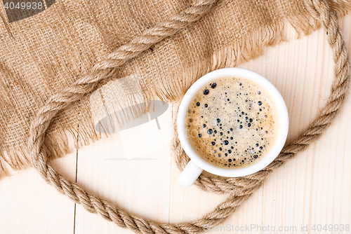 Image of Cup of coffee with foam on wooden table