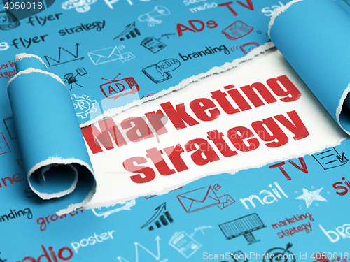 Image of Marketing concept: red text Marketing Strategy under the piece of  torn paper