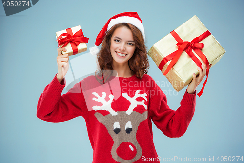 Image of Girl dressed in santa hat with a Christmas gifts