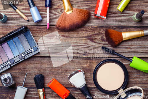 Image of Make-up brushes and cosmetics on a wooden background