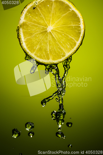 Image of Drops of lime juice falling down. Colorful background