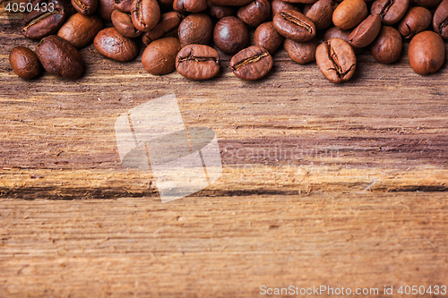 Image of Black coffee beans on wooden table,