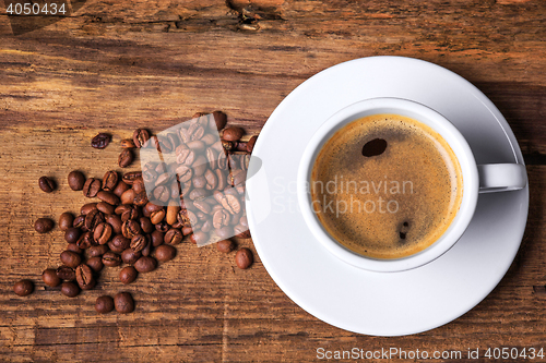 Image of Coffee cup on a wooden table. Dark background.