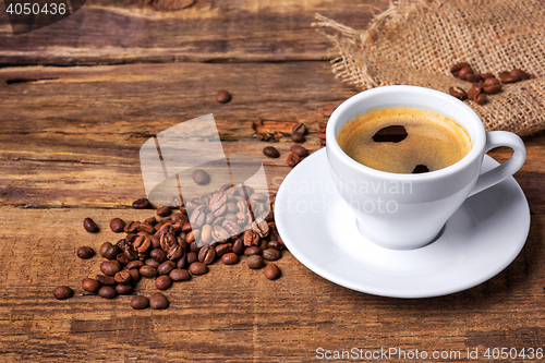 Image of Coffee cup on a wooden table. Dark background.