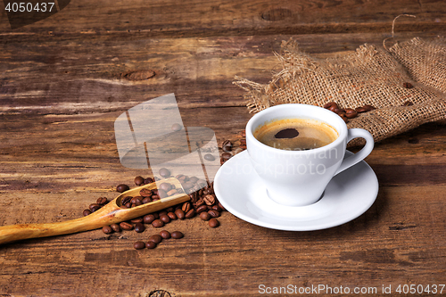Image of Coffee cup on a wooden table. Dark background.