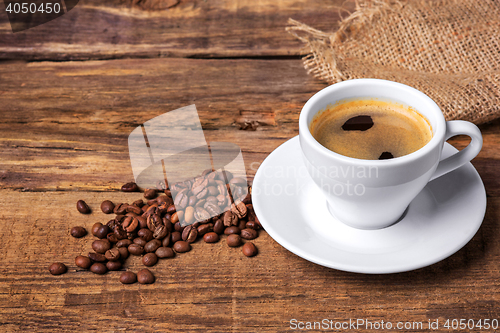 Image of Coffee cup on a wooden table. Dark background.