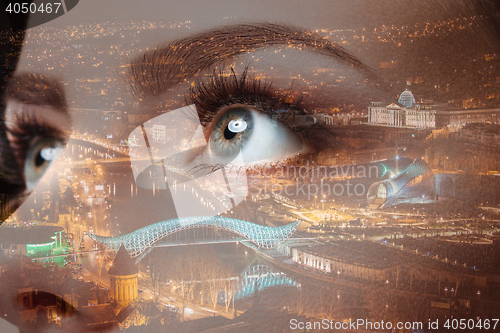 Image of Photo of woman eye and city night lights. Double exposure