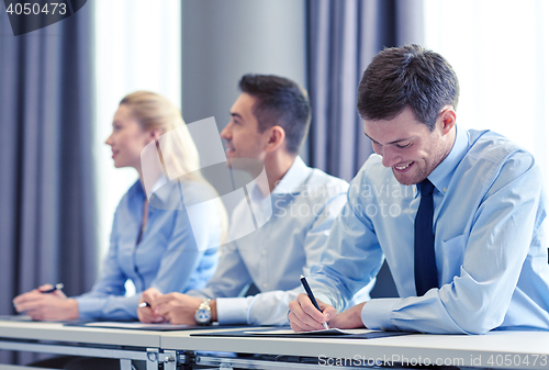 Image of group of smiling businesspeople meeting in office