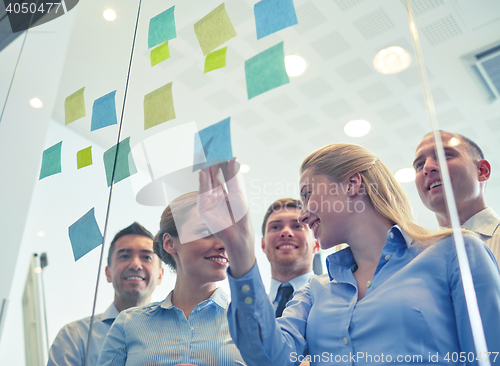 Image of smiling business people with marker and stickers