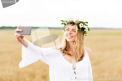Image of happy young woman taking selfie by smartphone