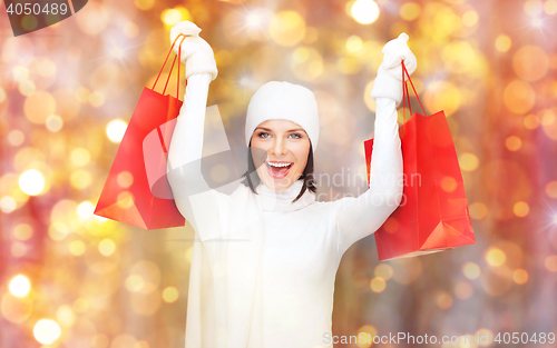 Image of happy woman in winter clothes with shopping bags