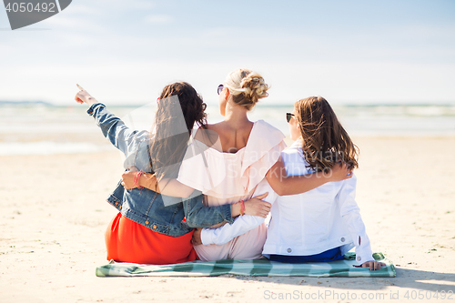 Image of group of young women hugging on beach