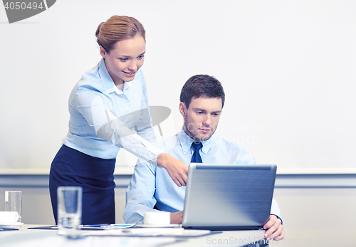 Image of businessman and secretary with laptop in office