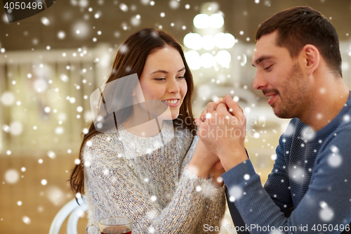 Image of happy couple holding hands at restaurant or cafe