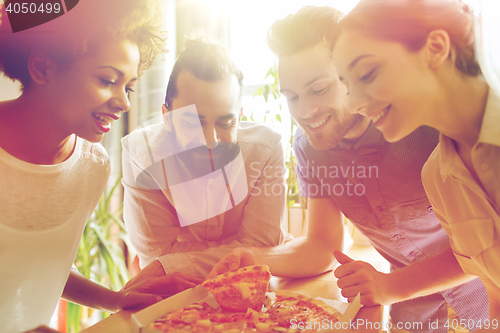 Image of happy business team eating pizza in office