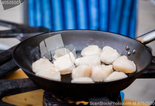 Image of close up of scallops frying in cast iron pan