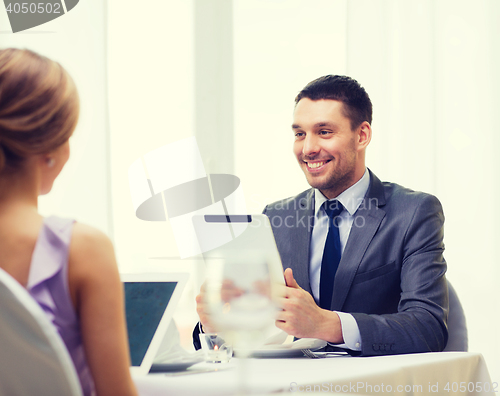 Image of man with tablet pc looking at wife or girlfriend