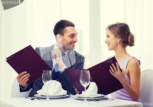Image of smiling couple with menus at restaurant