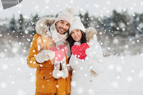 Image of happy couple with red hearts over winter landscape