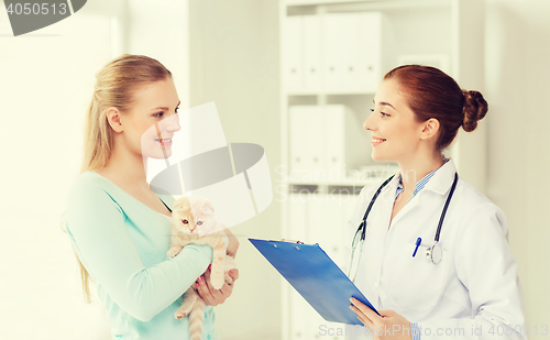 Image of happy woman with cat and doctor at vet clinic