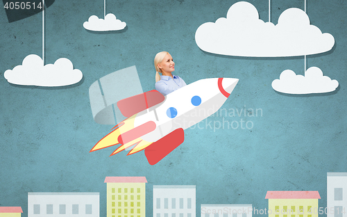 Image of businesswoman flying on rocket above cartoon city