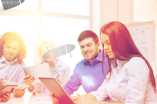 Image of smiling team with table pc and papers working